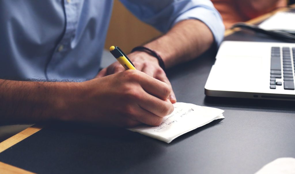 Person writing out a plan on a piece of paper