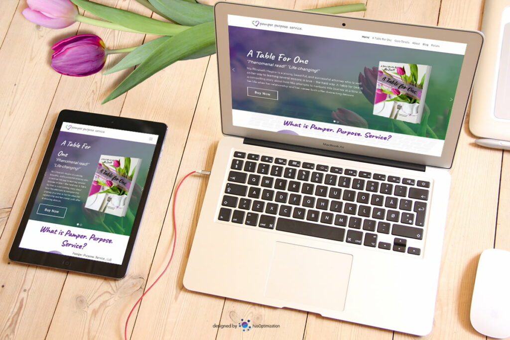 Tablet sitting next to a laptop on a table with Pamper. Purpose. Service. website open
